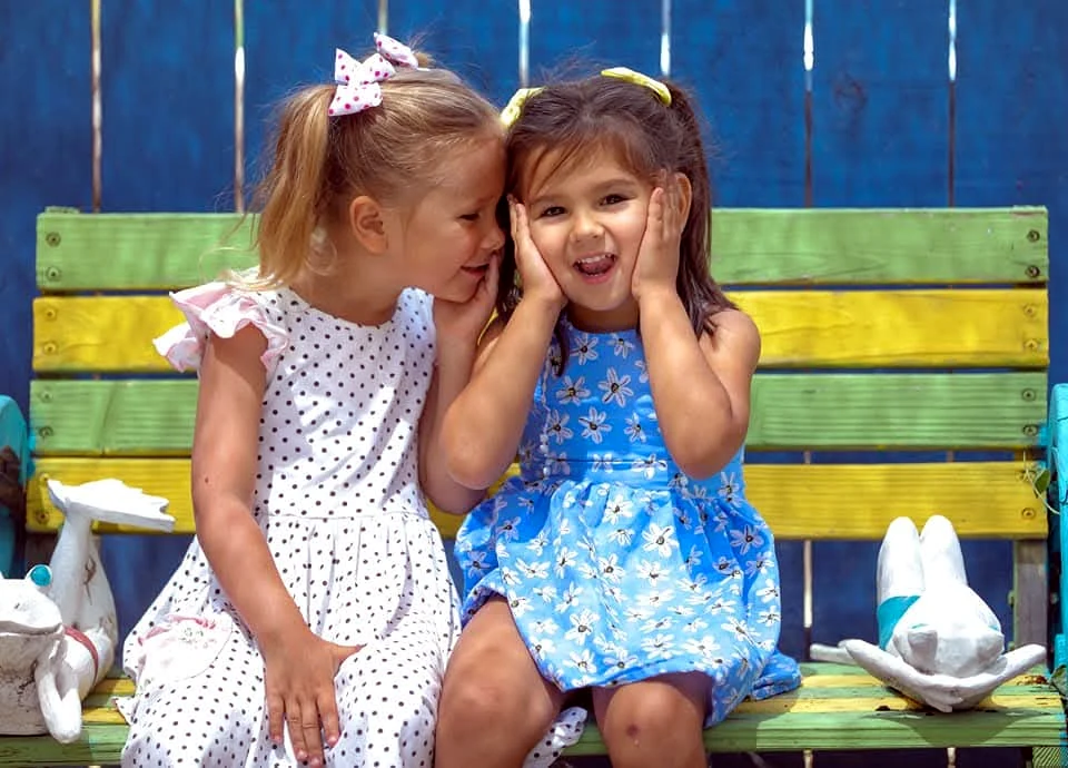Two children sharing a friendly and playful learning moment