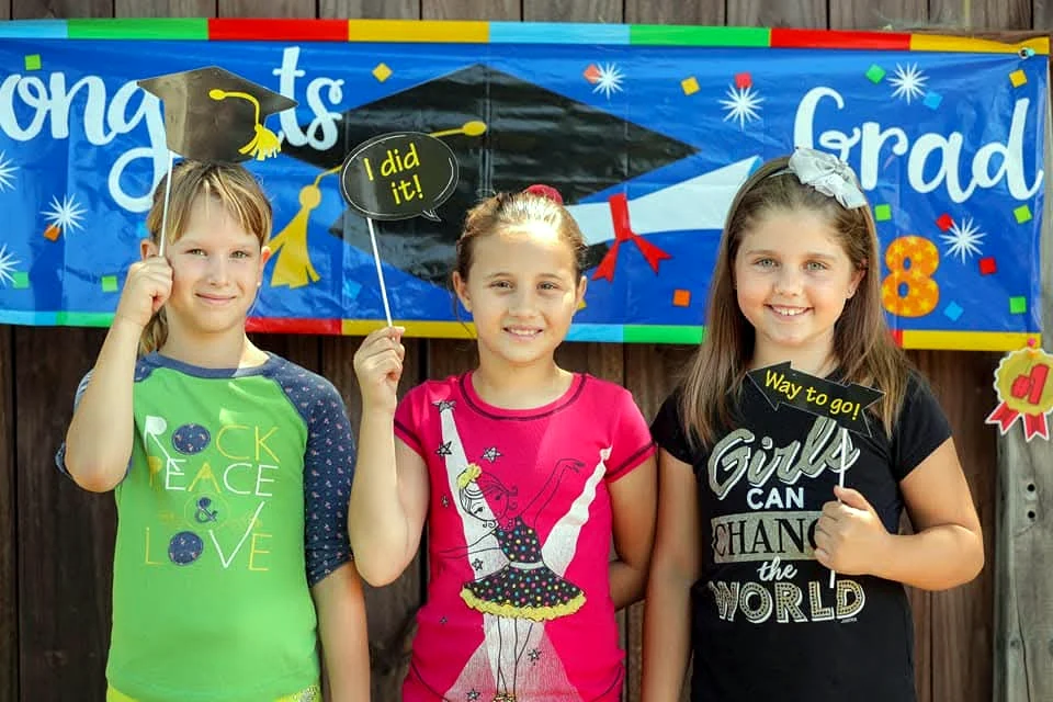 Group of children celebrating a graduation-themed activity